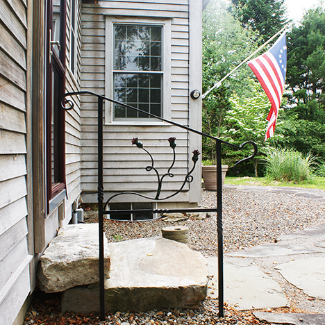 Railing over two stone steps with thistle decoration.